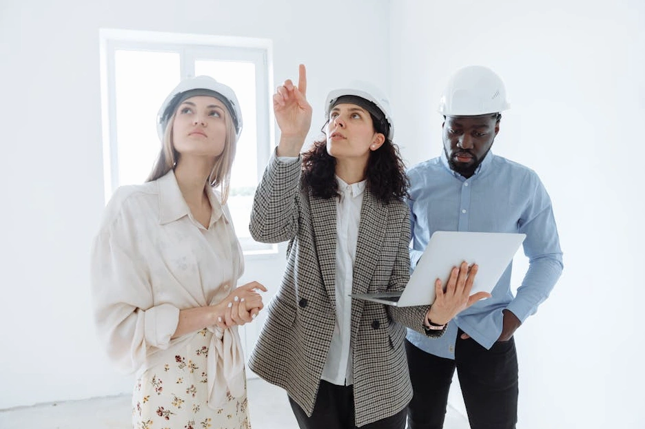 An energy consultant reviewing blueprints with solar panels in the background